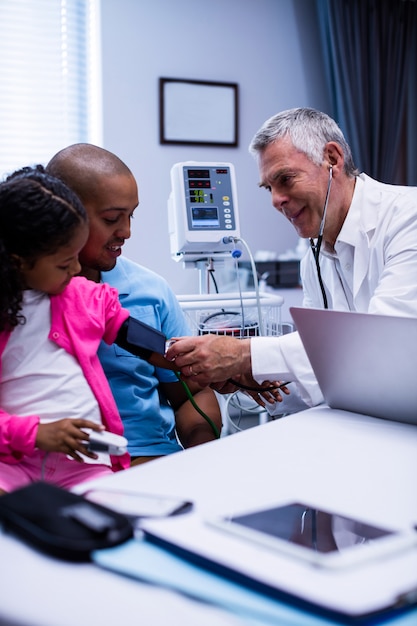 Doctor checking patient blood pressure