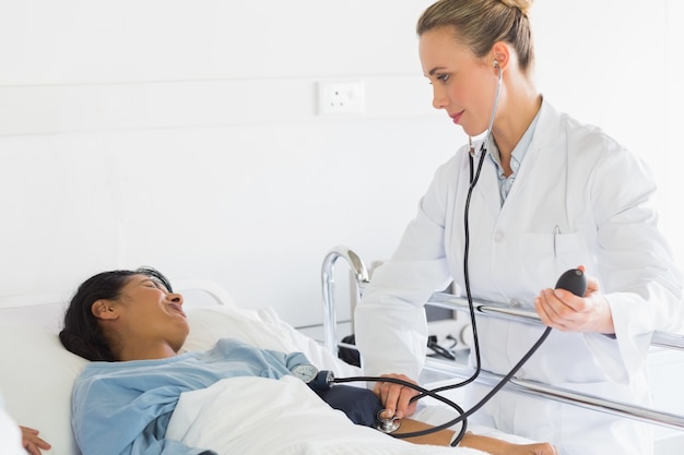 Doctor checking patients blood pressure