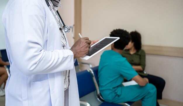 Doctor checking and writing about patient's health at hospital. Health and wellness.