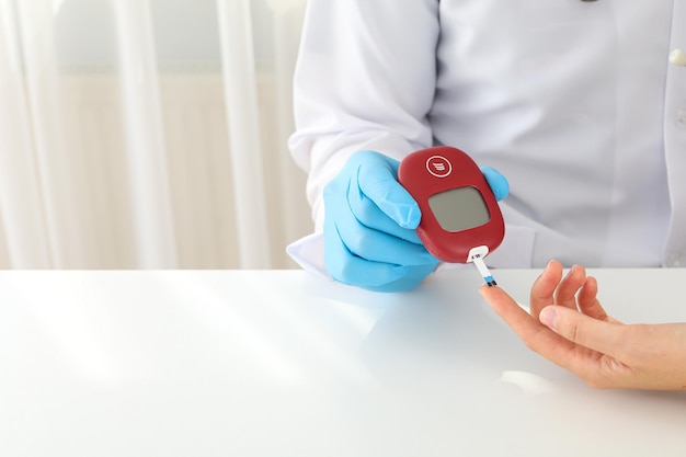 The doctor checks the blood sugar level using a glucometer Diabetes treatment concept