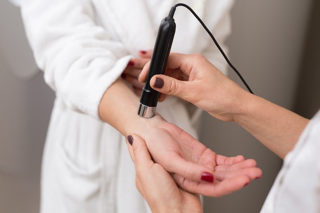 Doctor checks the tanning level on the skin of the girl.