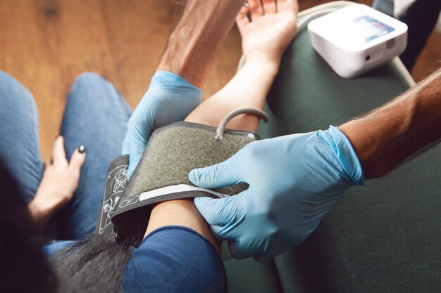 The doctor checks the woman's blood pressure