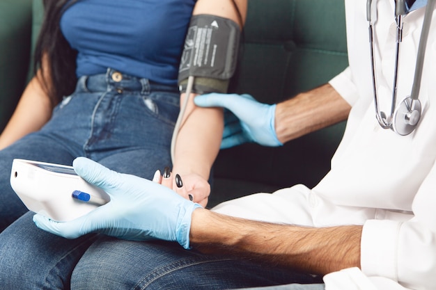 The doctor checks the woman's blood pressure