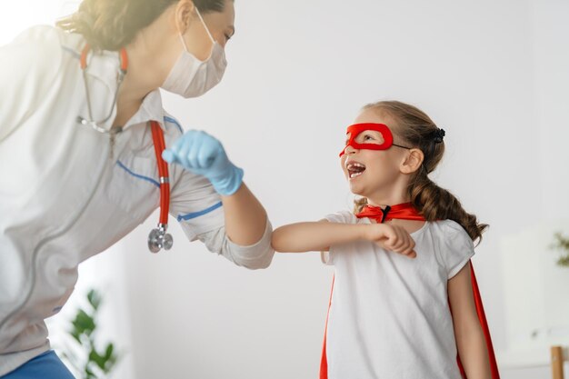 Doctor and child at hospital Kid in superhero costume