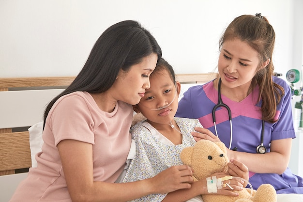 Doctor and child with mother in hospital