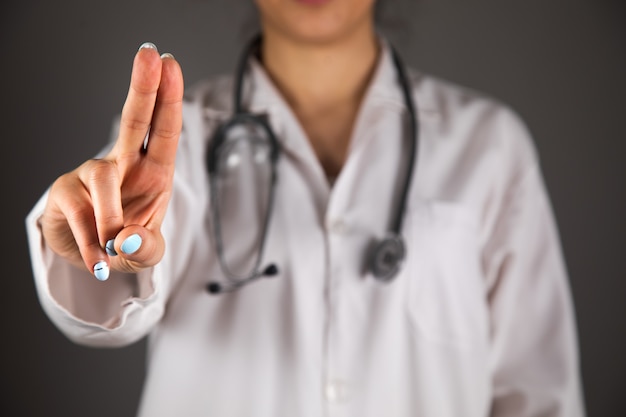 Doctor clicks on a virtual screen on a gray wall