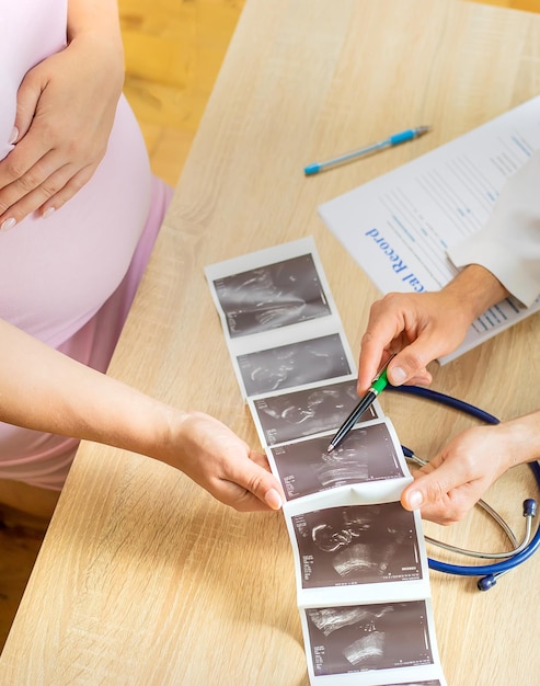 Foto un medico in una clinica esamina una donna incinta focalizzazione selettiva