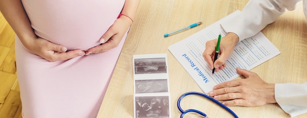 A doctor in a clinic examines a pregnant woman.