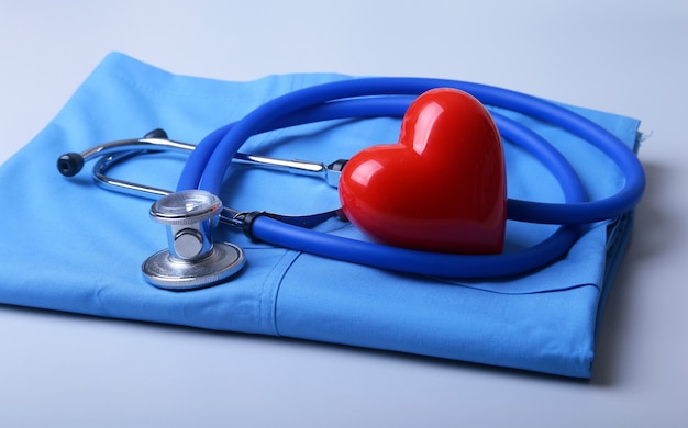 Doctor coat with medical stethoscope and red heart on the desk