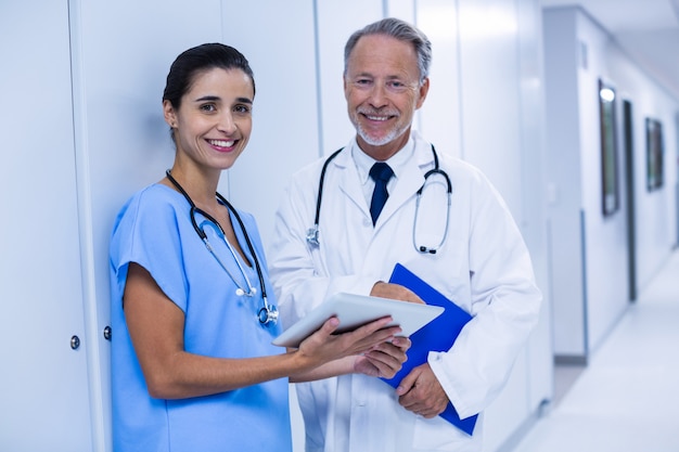 Doctor and colleague discussing over digital tablet