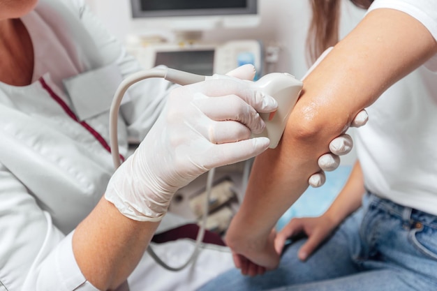 Doctor conducting ultrasound examination of patients elbow in clinic