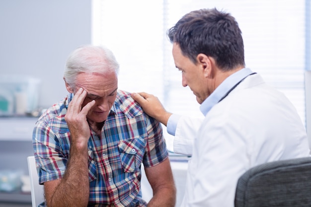 Doctor consoling senior man