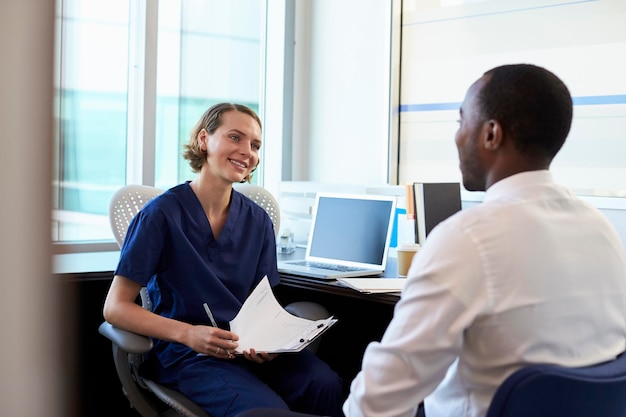 Doctor In Consultation With Male Patient In Office