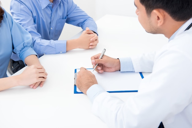 Doctor consulting with young couple patients