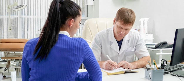 Doctor consulting young woman in his office