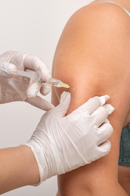 doctor cosmetologist makes an injection in the arm of the patient mesotherapy procedure