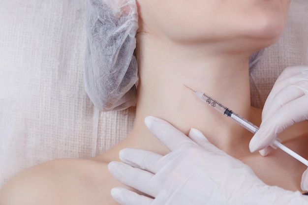 Foto il medico cosmetologo esegue la procedura di ringiovanimento delle iniezioni facciali cosmetologia per la cura della pelle