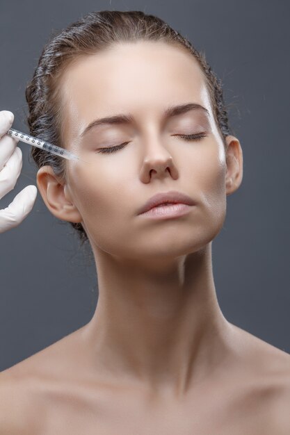 The doctor cosmetologist makes the Rejuvenating facial injections procedure