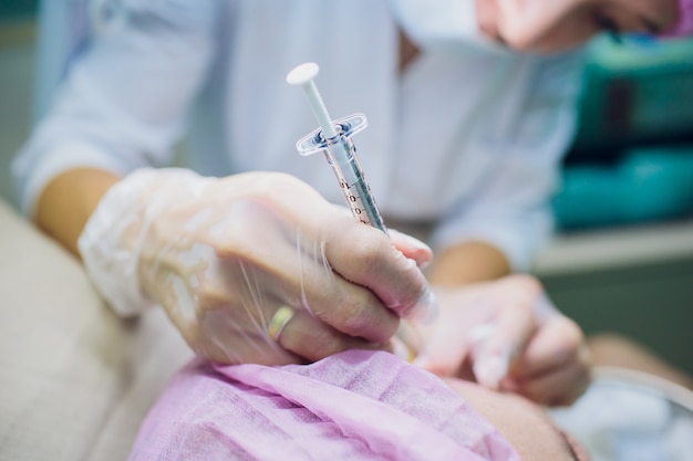 The doctor cosmetologist makes the Rejuvenating facial injections procedure