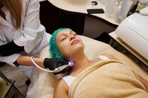 The doctor cosmetologist performs massage with microcurrents