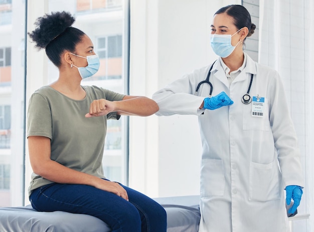 Photo doctor covid and greeting medical healthcare expert with patient in safe elbow with masks in a hospital happy women following safety social distance rules to prevent the spread of virus at clinic