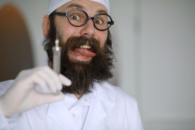 미친 의사 미친 수염 과학자는 과학 실험실에서 실험을 수행합니다 주사기와 청진기를 사용하여 연구를 수행합니다