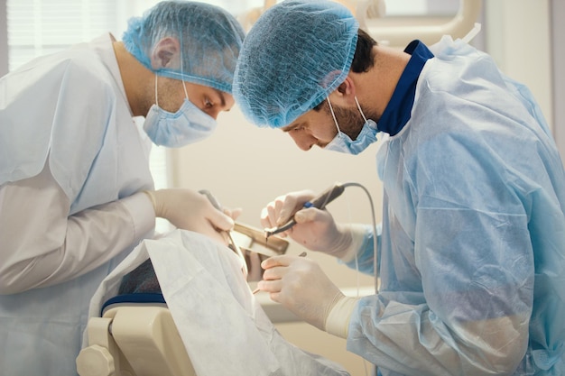 Photo doctor dentist and assistant during stomatology operation, close up