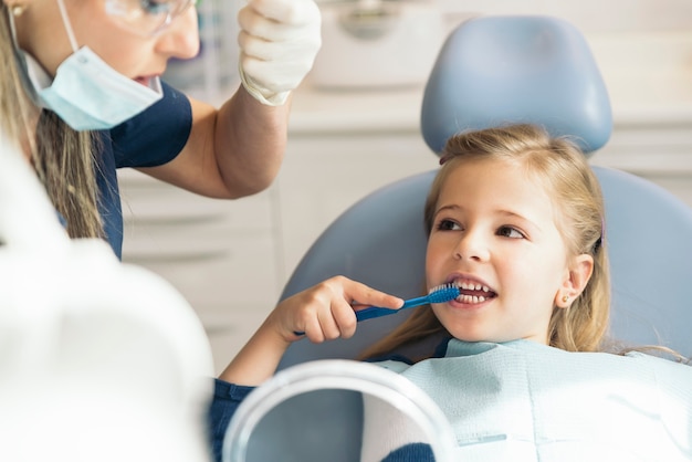 Foto dentista medico che insegna a un bambino a lavarsi i denti. concetto di dentista.