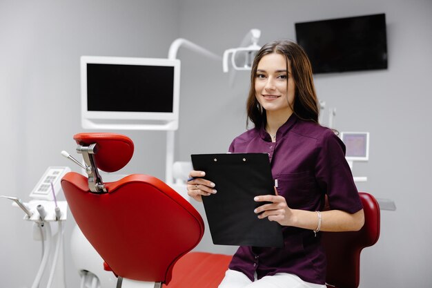 Doctor dentist working in office using clipboard and making notes