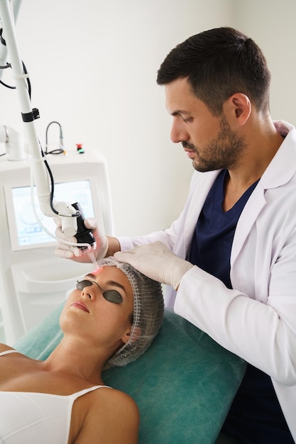 Doctor dermatologist and woman client during laser skin resurfacing treatment in a medical aesthetic clinic