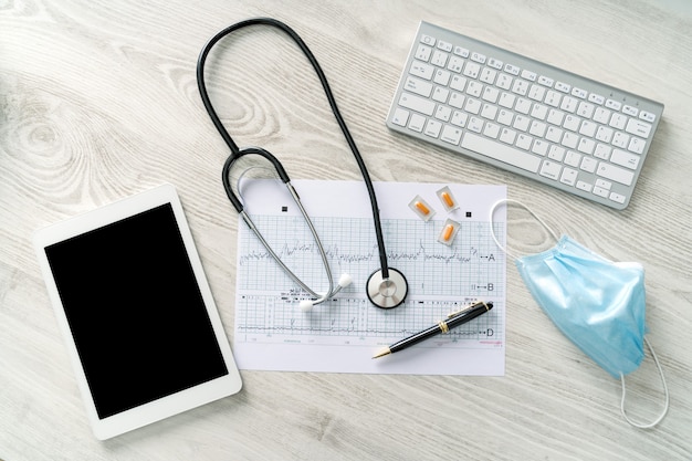 Photo doctor desk with stethoscope, mask, and tablet