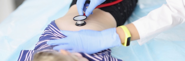 Doctor diagnoses lungs with stethoscope of little girl