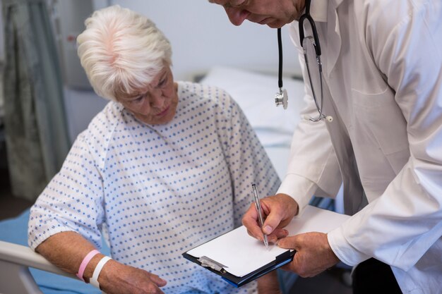 Doctor discussing medical report with senior patient