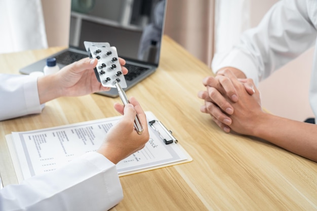 Photo doctor discussing with the patient using the medicine something and recommend treatment methods presenting results on report medicine and healthcare concept