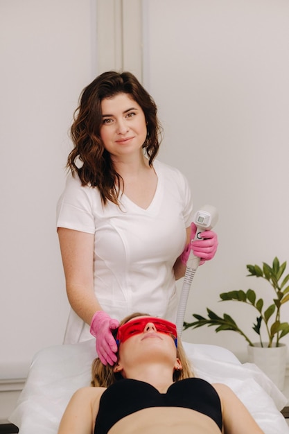 A doctor does laser hair removal for a client of unwanted facial hair in a beauty salon