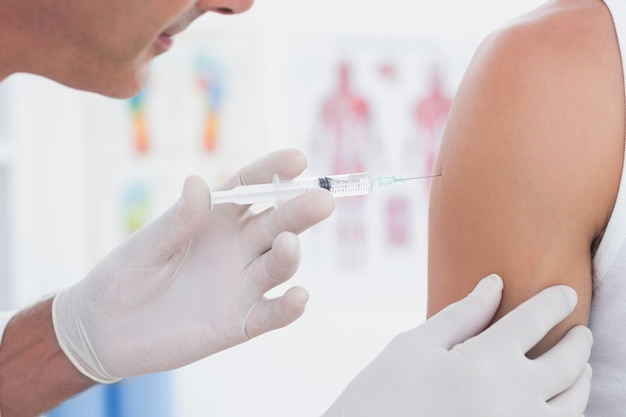 Doctor doing an injection to his patient 