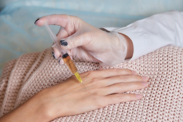 Doctor doing stem cell therapy on a patients elbow after the injury treating knee pain with platelet