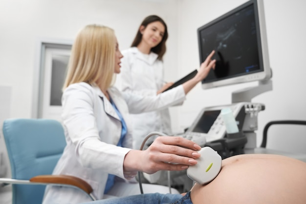 Doctor doing ultrasound examination of pregnant woman.