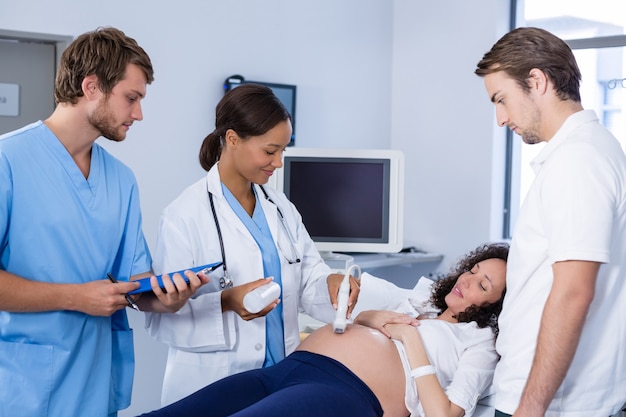 Doctor doing ultrasound scan for pregnant woman