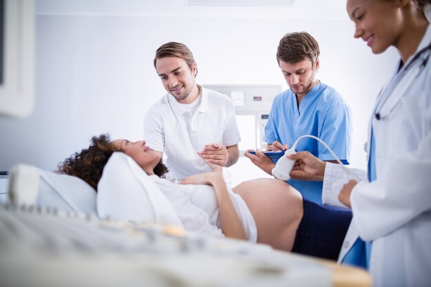 妊娠中の女性の超音波スキャンを行う医師