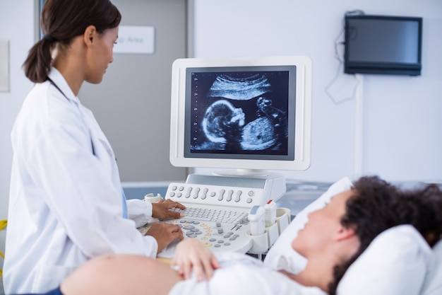 Doctor doing ultrasound scan for pregnant woman