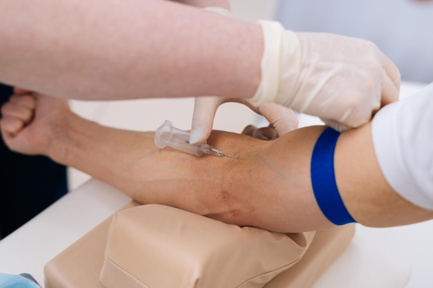 Doctor drawing blood sample from arm for blood test closeup Phlebotomist technician drawing blood for testing Coronavirus COVID19 disease infestation Concept of healthcare and medicine