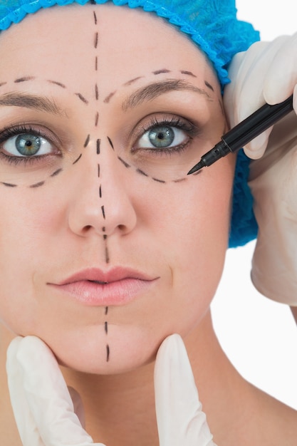 Doctor drawing on woman&#039;s face for face lift