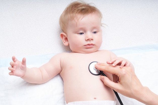 의사는 청진기로 아기를 검사합니다. 아기의 폐를 듣는다