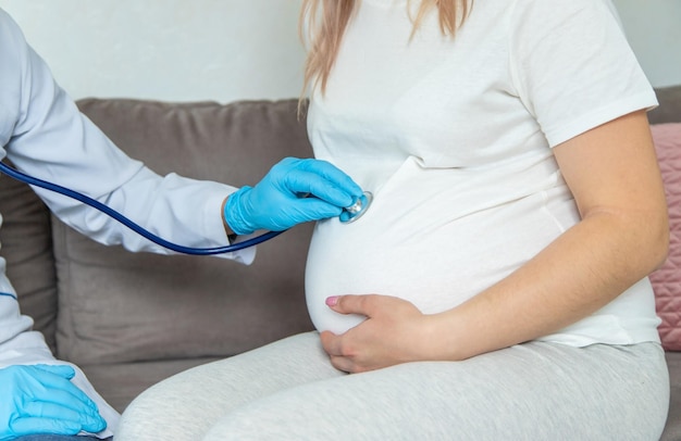 The doctor examines the belly of a pregnant woman Selective focus