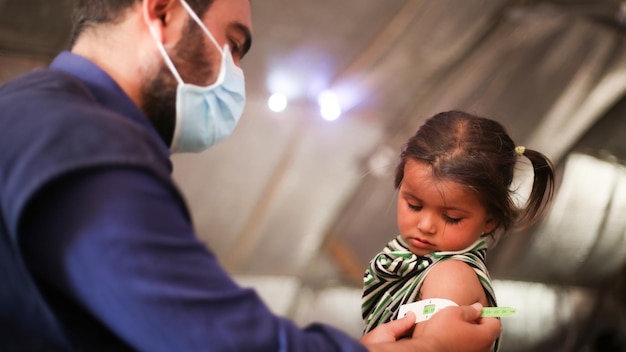 Foto il medico esamina la malnutrizione infantile misurando la malnutritione utilizzando la cinghia muac circonferenza media-superiore del braccio aiutare i rifugiati