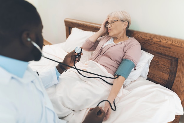 The doctor examines an elderly patient in a nursing home.