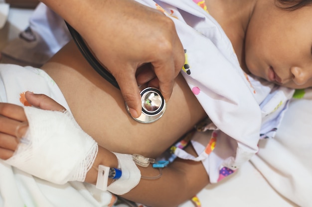 Doctor examining asian girl listen her lung and heart sound with stethoscope