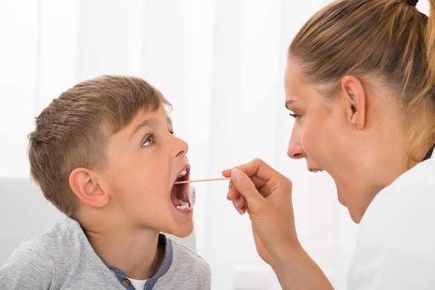 Doctor Examining Boy's Mouth