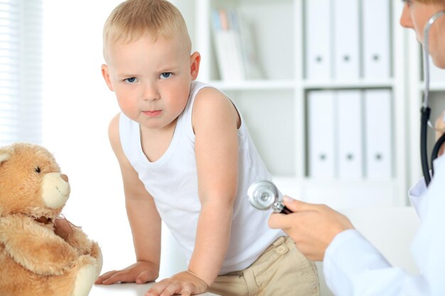 Доктор, изучающий ребенка с помощью стетоскопа